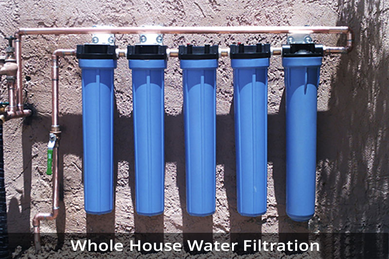 A group of blue water filters hanging on the side of a wall.